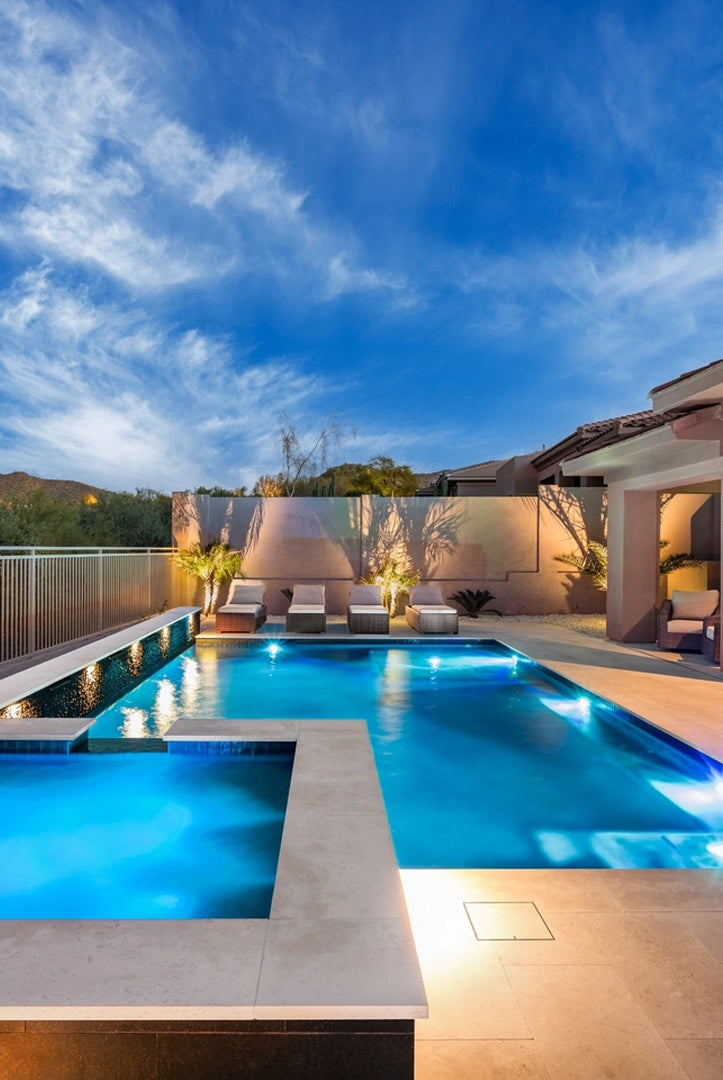 Beautiful pool at dusk showing HIDE Skimmer Cover beside Pool and Spa with lights