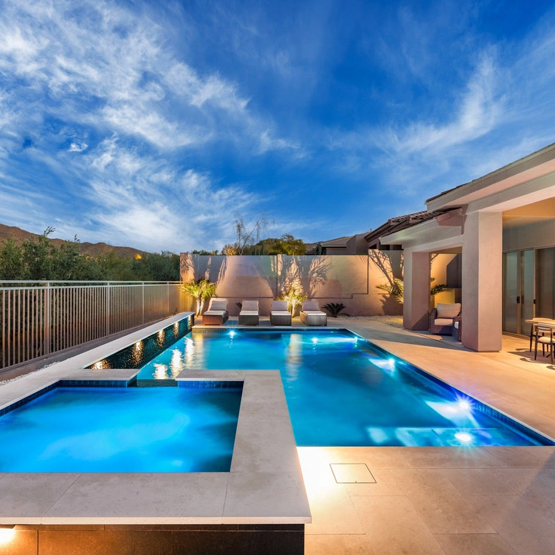 Beautiful pool at dusk showing HIDE Skimmer Cover beside Pool and Spa with lights