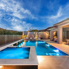 Beautiful pool at dusk showing HIDE Skimmer Cover beside Pool and Spa with lights